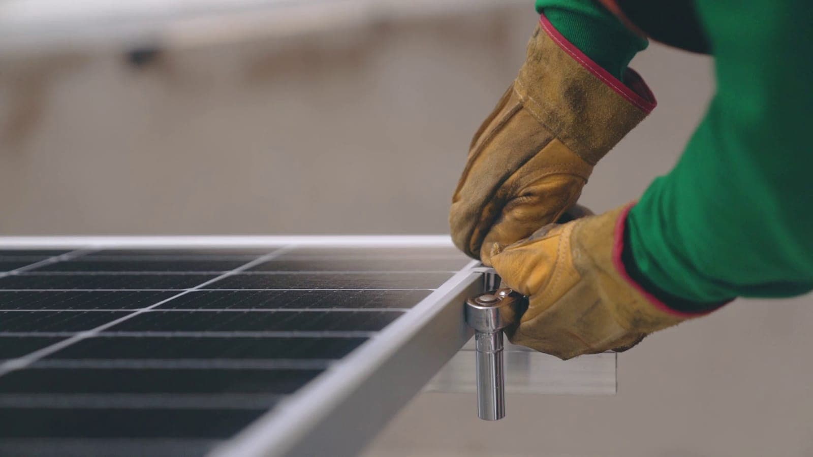 Technician tightening a clamp on a commercial solar panel