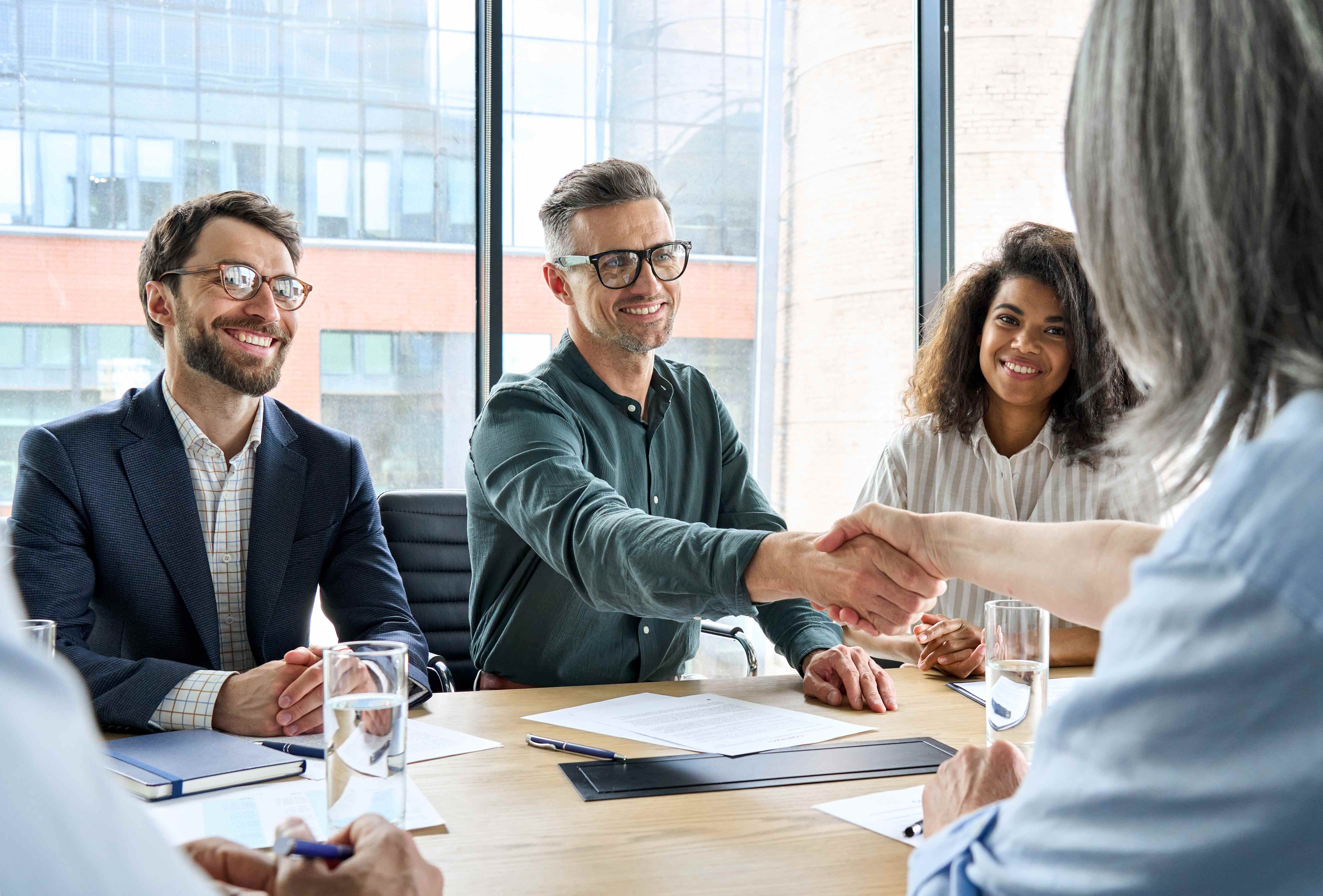 Business professionals having a meeting and shaking hands, demonstrating our people-first approach